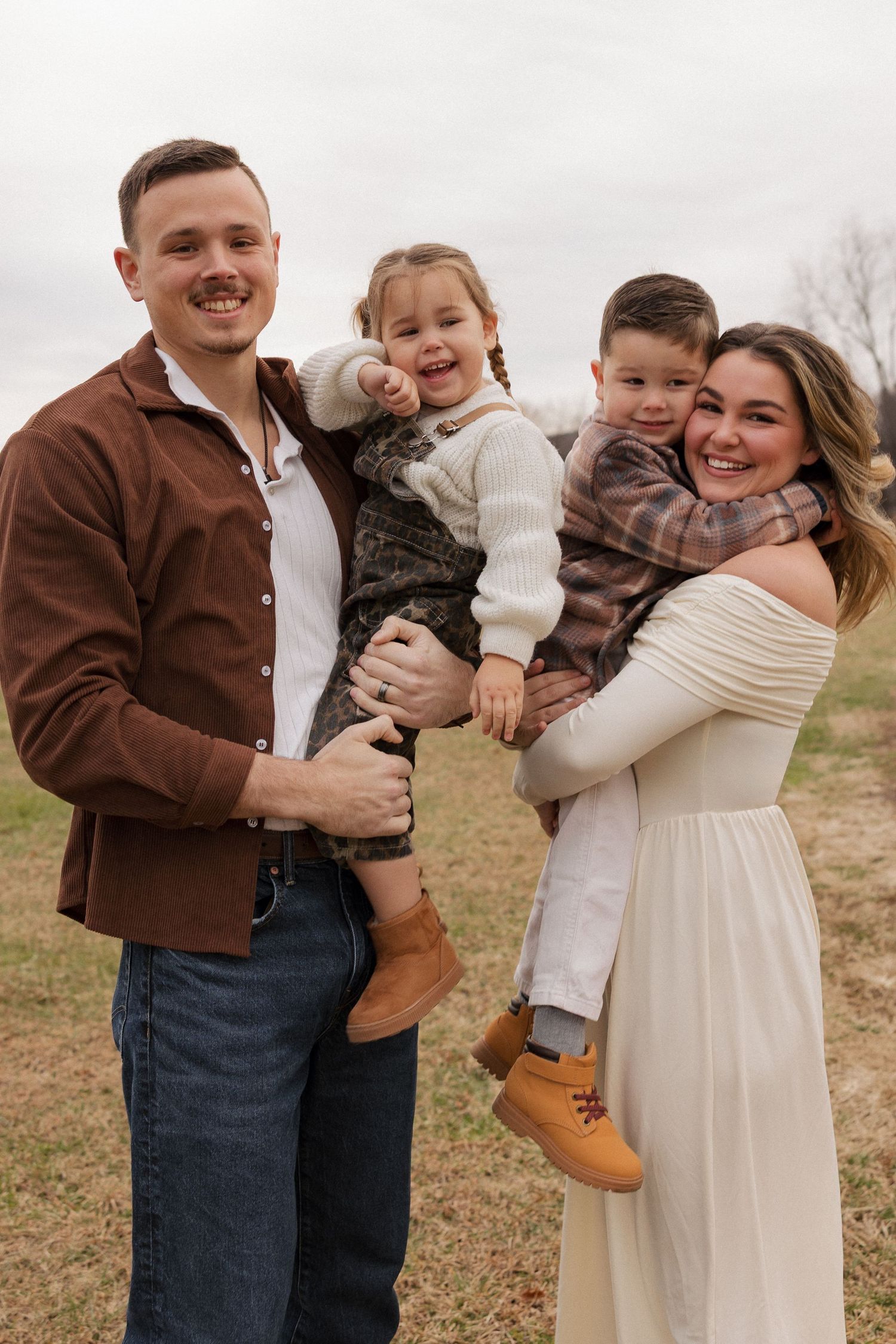 Family of 4 walking around a beautiful field of hay bales
