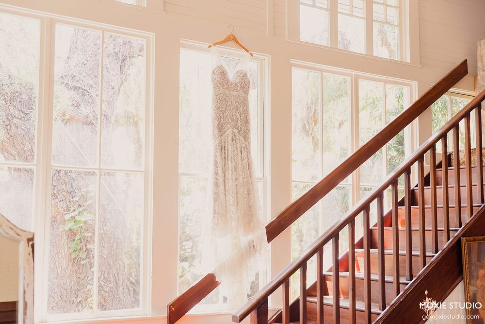 Elegant staircase with wooden railings and natural light streaming through large windows in a classic interior.