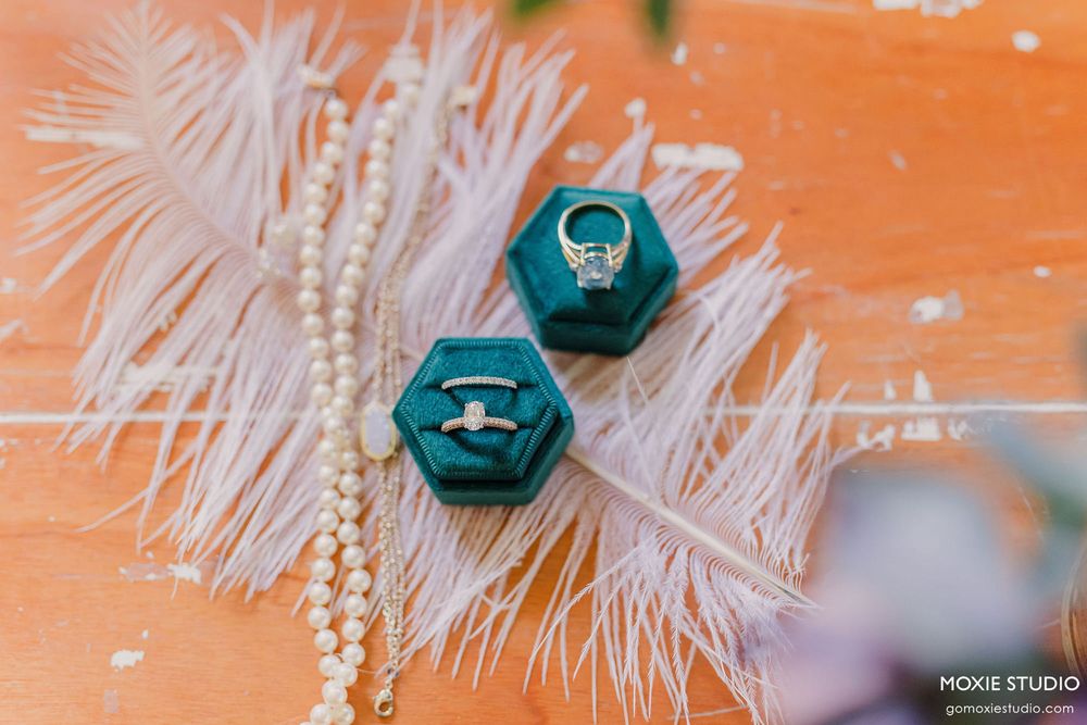 White feathery Christmas ornaments and teal baubles decorate a festive holiday display against an orange background.