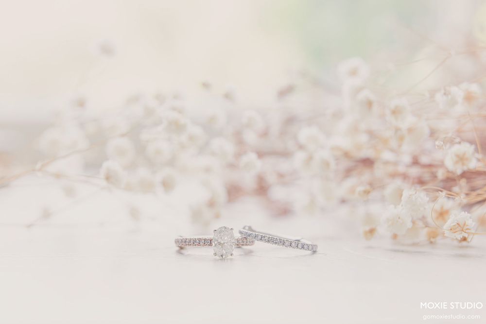 Delicate engagement ring with diamond solitaire sparkles against soft blurred background in natural light.