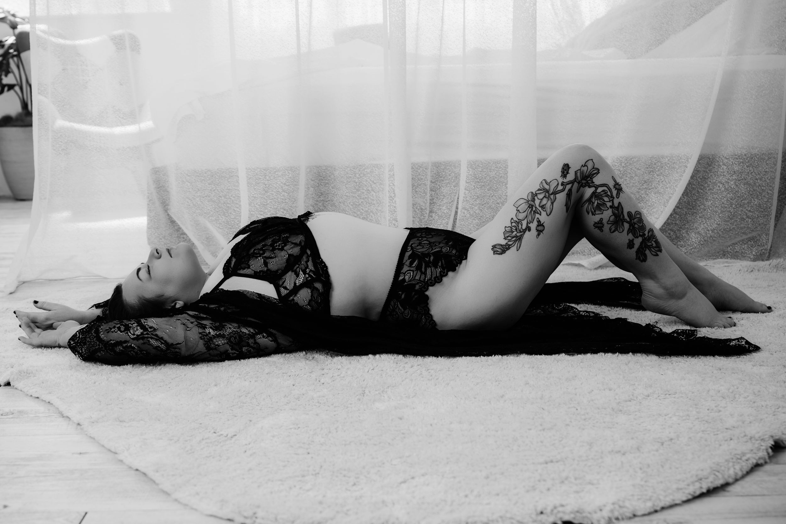 A black and white panoramic photo sequence shows a figure lying on the ground and rolling in continuous motion.