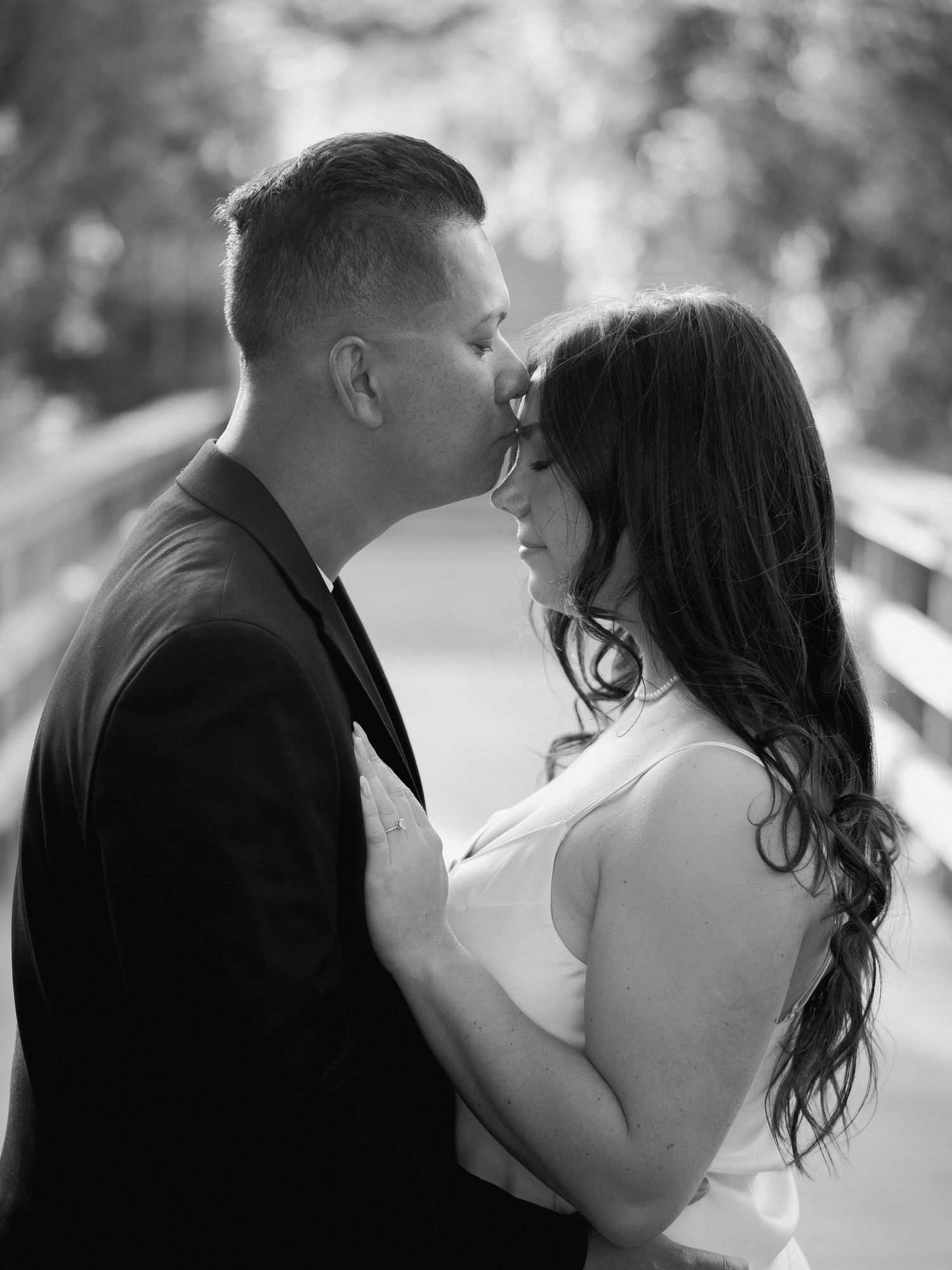 An intimate black and white portrait of a couple sharing a tender moment.