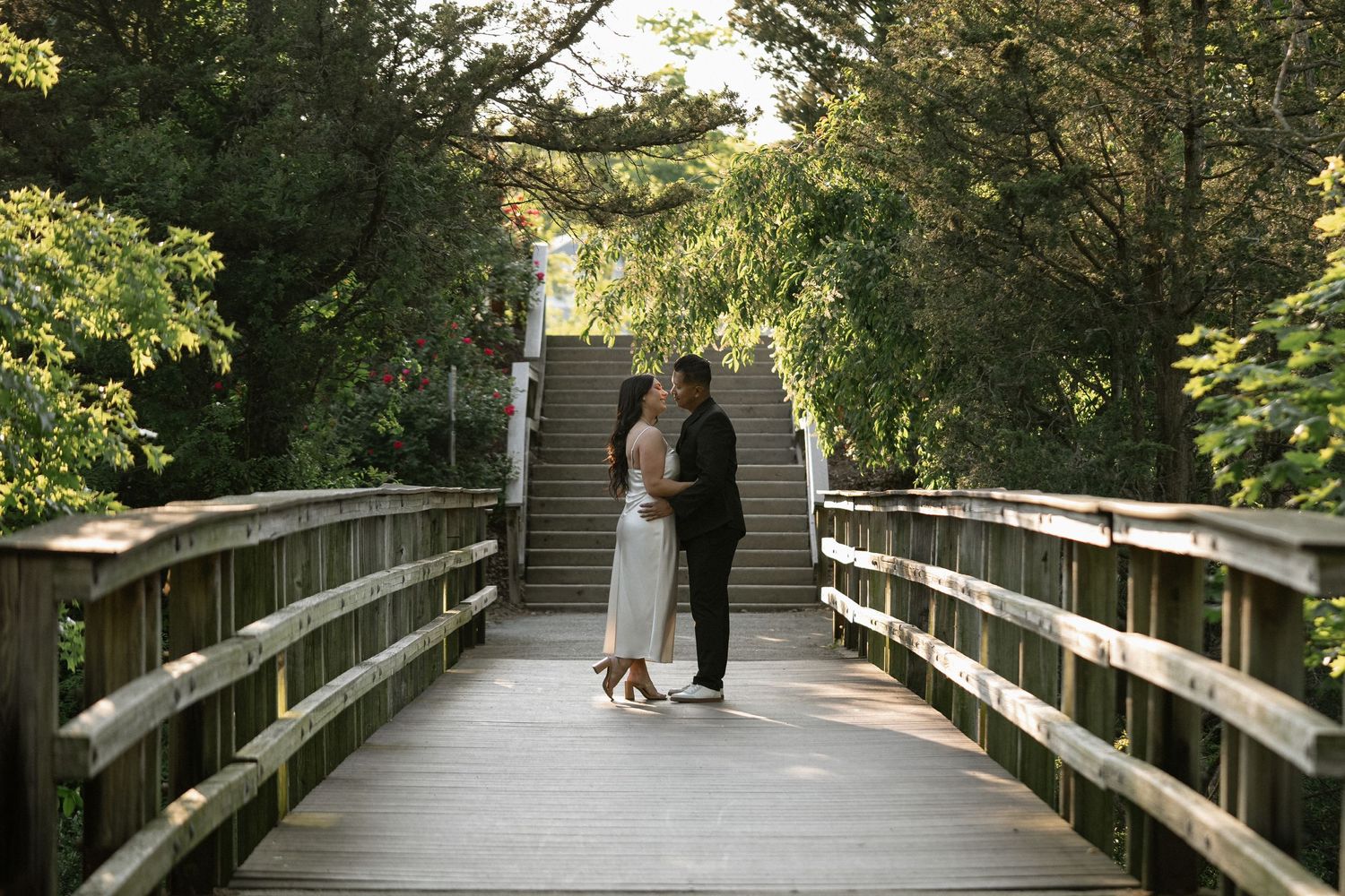 Long wooden boardwalk stretching through a peaceful wooded area.