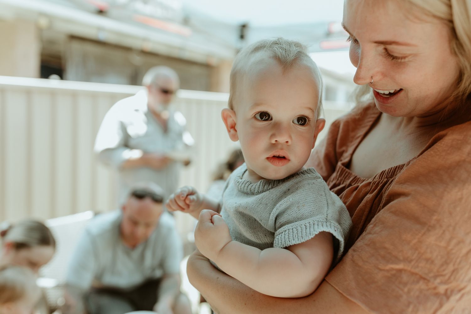 A candid family moment outdoors with multiple generations gathered together.
