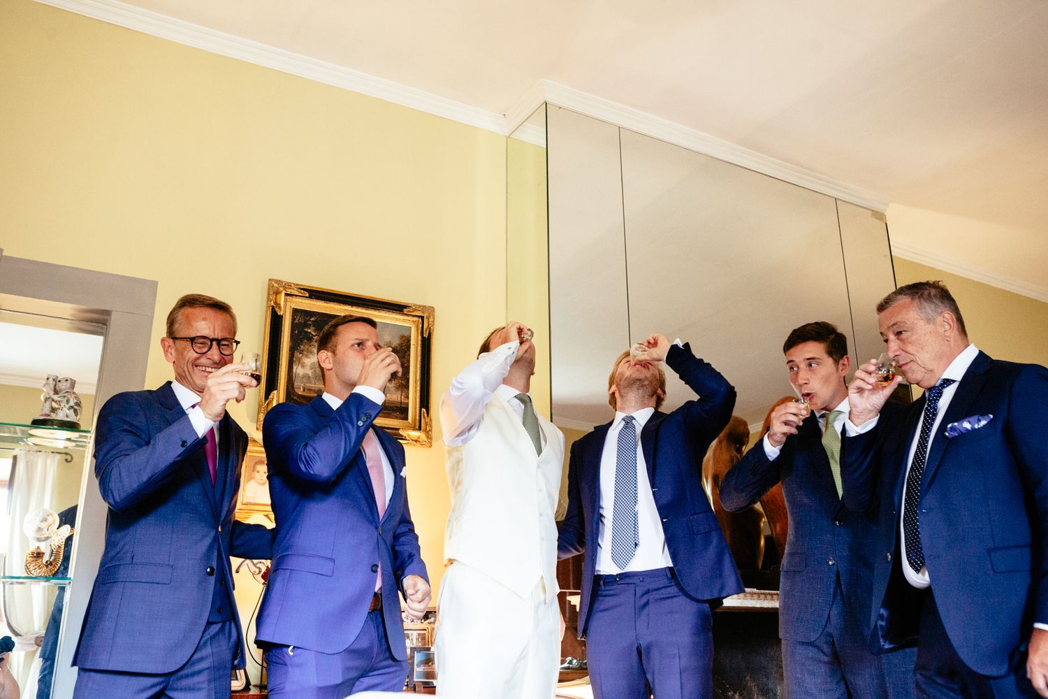 the groomsmen take a shot before the wedding