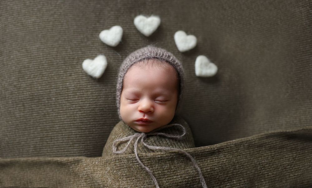 In home newborn session Bump birth and beyond, baby boy snuggled earthy green tones. Best newborn photographer in Sydney