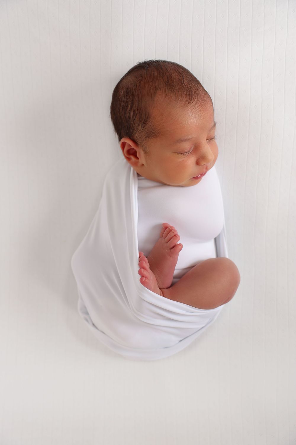 Newborn photoshoot, Penrith and surrounding suburbs. newborn boy in white set up.