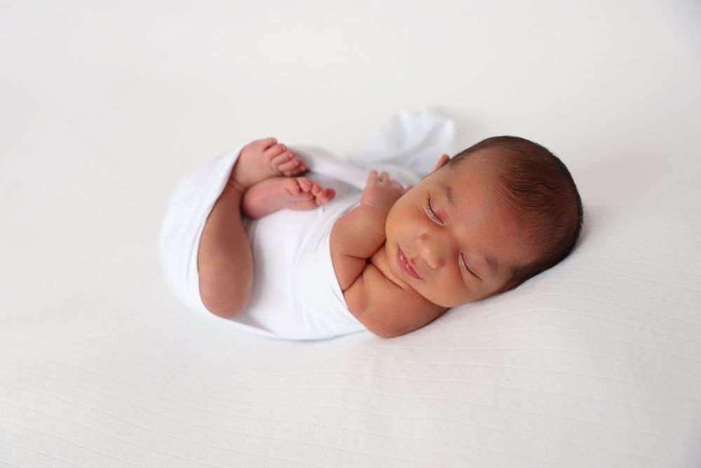 Newborn photoshoot, Penrith and surrounding suburbs. newborn boy in white set up.