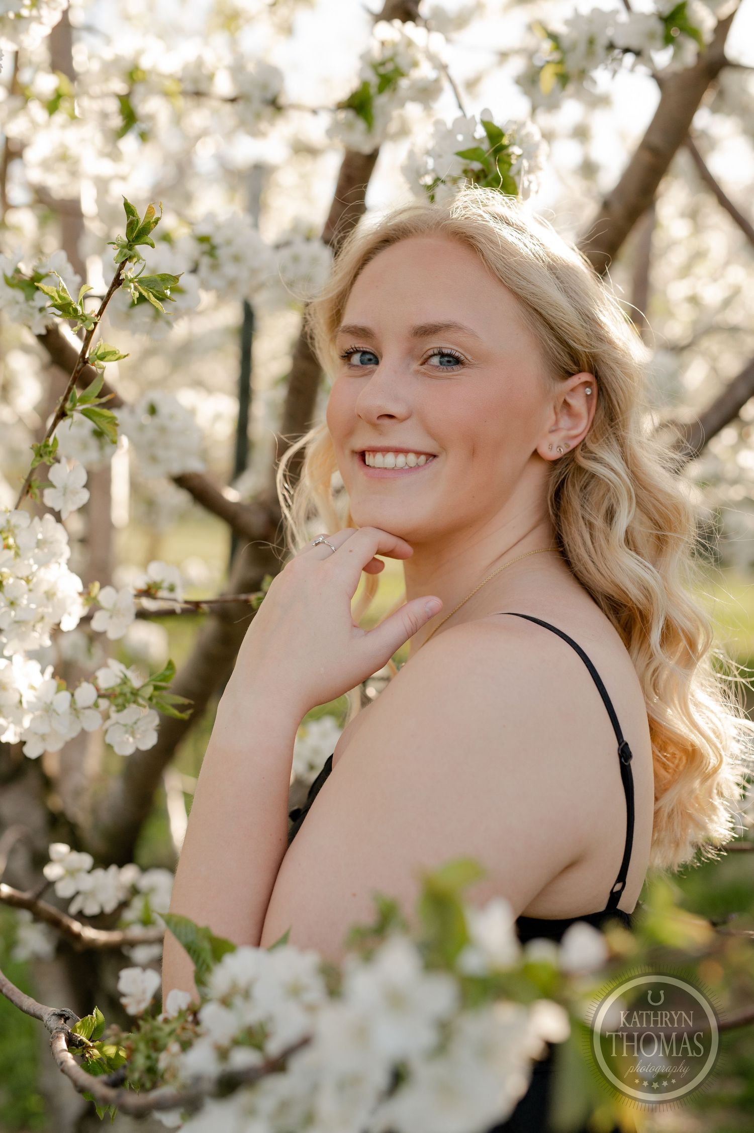 Intimate portrait framed by delicate white spring blossoms in natural light.