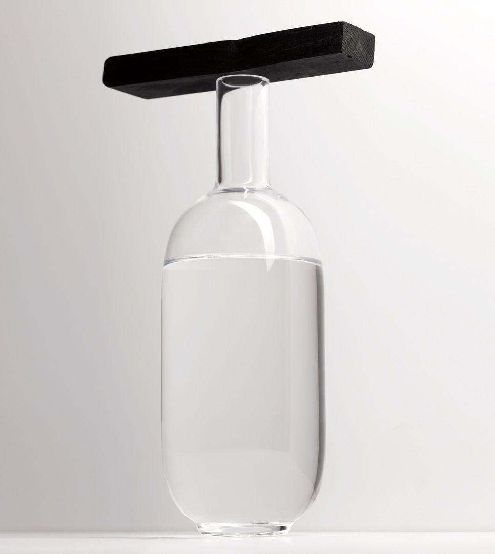 Black & white image of elegant bottle with activated charcoal with a white background for editorial website