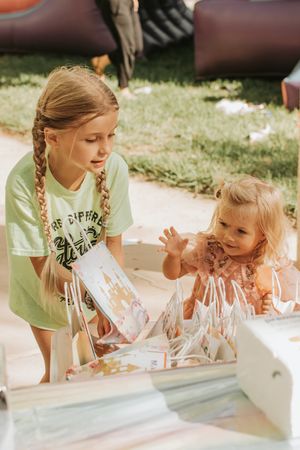 Two people looking at party activities together at an outdoor celebration.