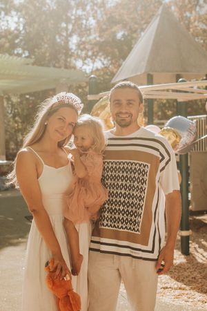 Family enjoying a warm sunny day outdoors with a patterned black and white blanket in the background.