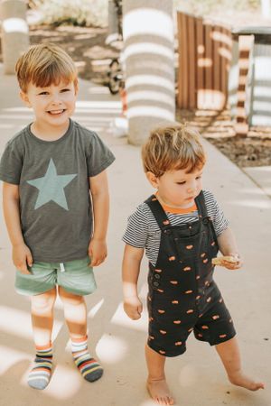 Child in star shirt and overalls playing outdoors in sequence of candid movements.