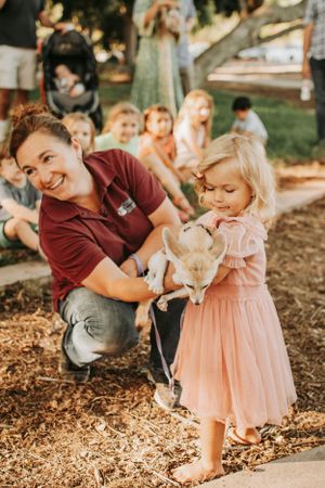 Family playing together on wood chips in a park setting.