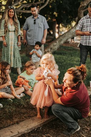Candid outdoor family gathering with people sitting on ground.