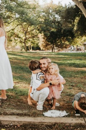 Family sharing loving moments together on park path at sunset.