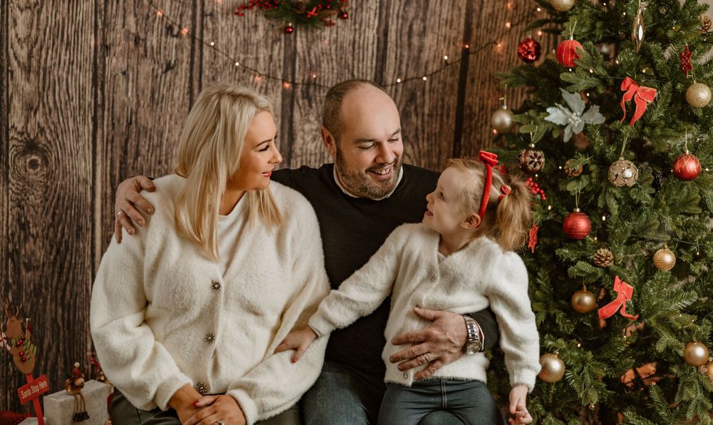 family photo in studio next to the Christmas tree