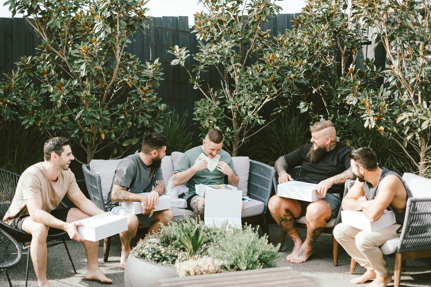 Group sitting in garden patio area reviewing documents together.