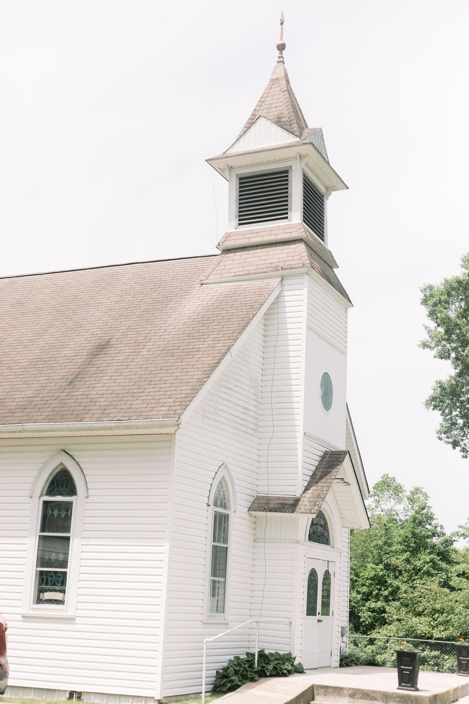 White country church exterior with steeple and arched windows photographed from different angles.