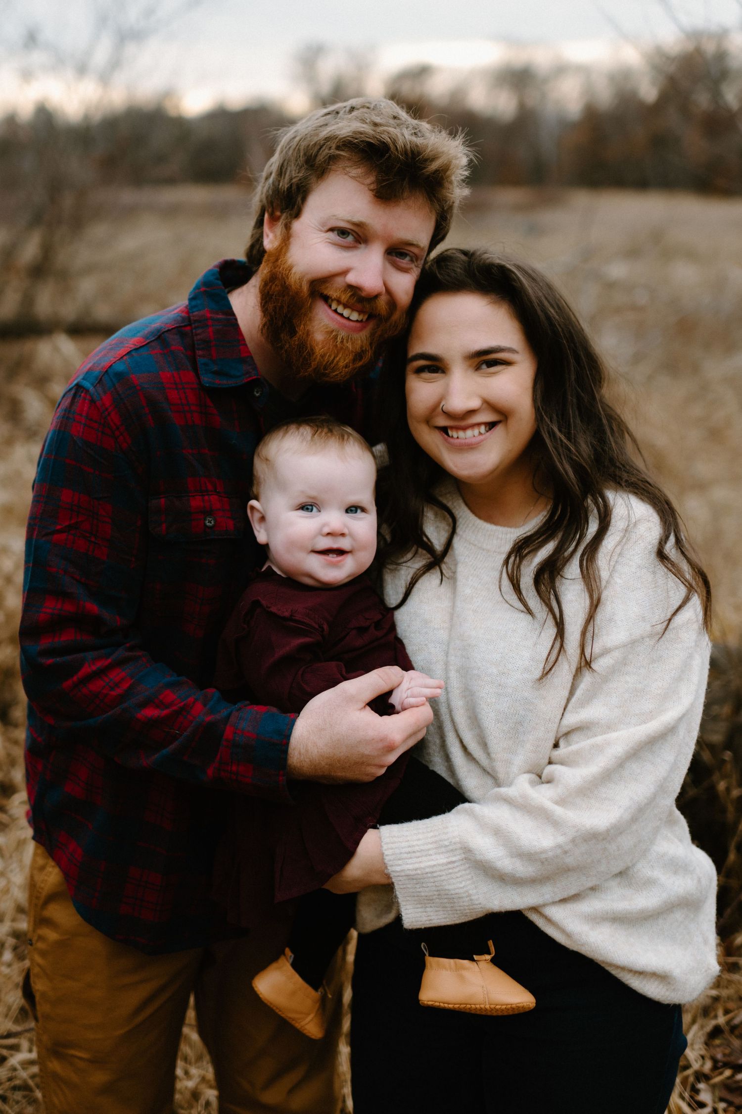 Happy family shares warm embrace outdoors during autumn photoshoot.