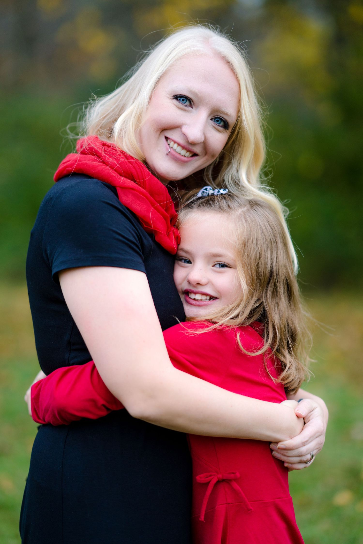 A heartwarming outdoor photo series of a mother and child embracing while wearing red and black.
