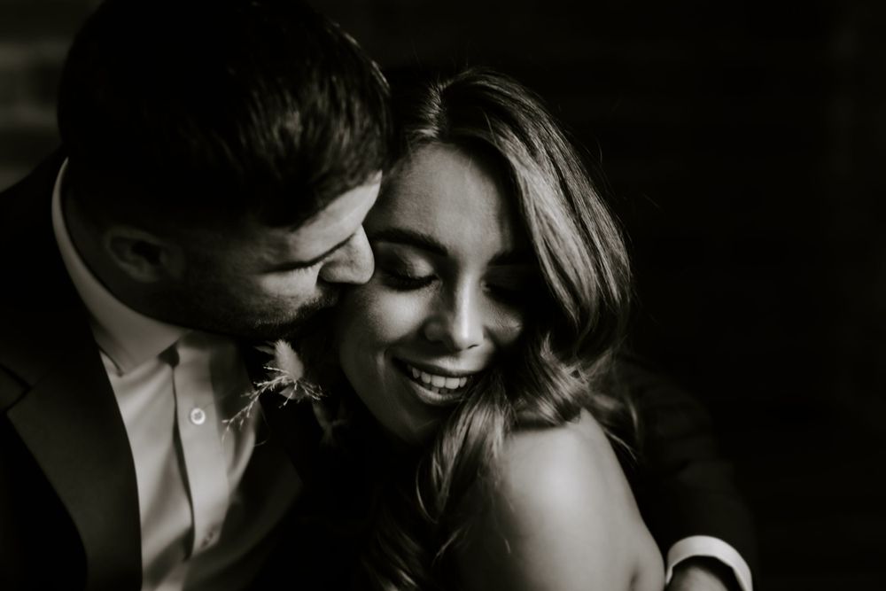 Black and white intimate portrait of couple sharing tender moment.