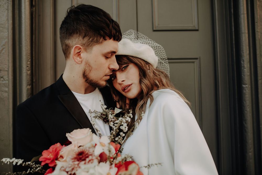 An intimate portrait of a couple in wedding attire against a classic door.