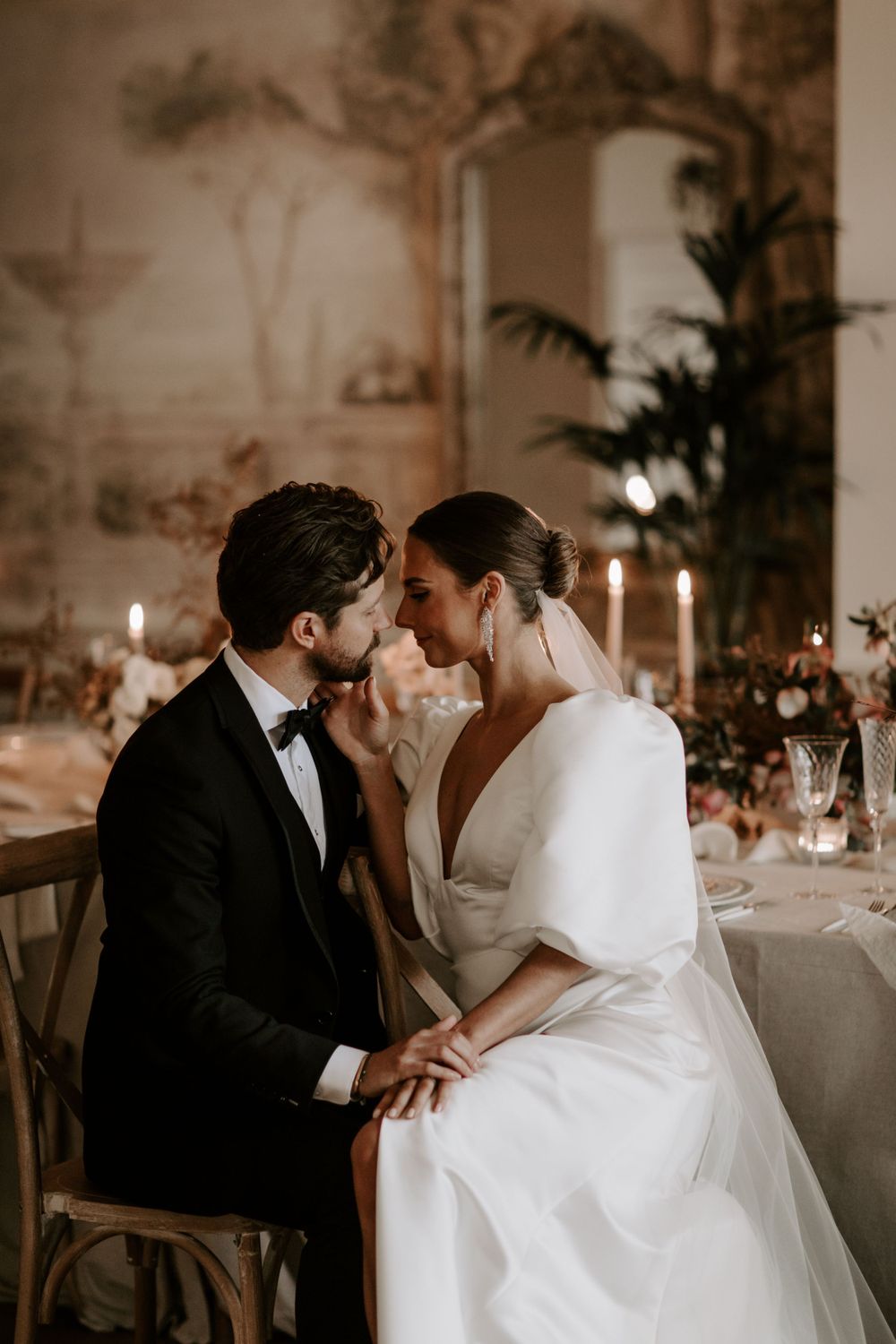 A romantic candlelit wedding reception scene with elegant table settings and intimate ambiance.
