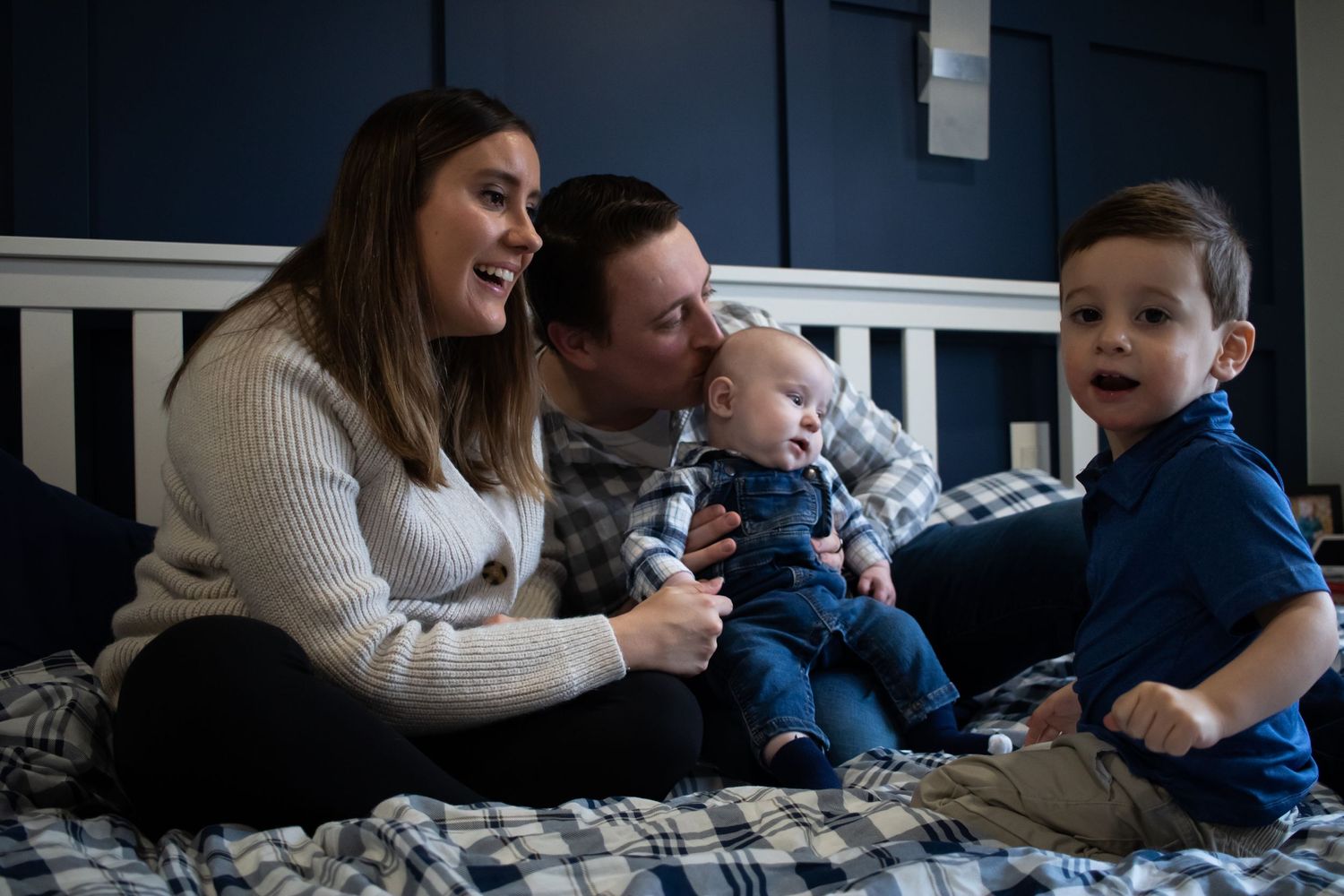 A family of four on a bed
