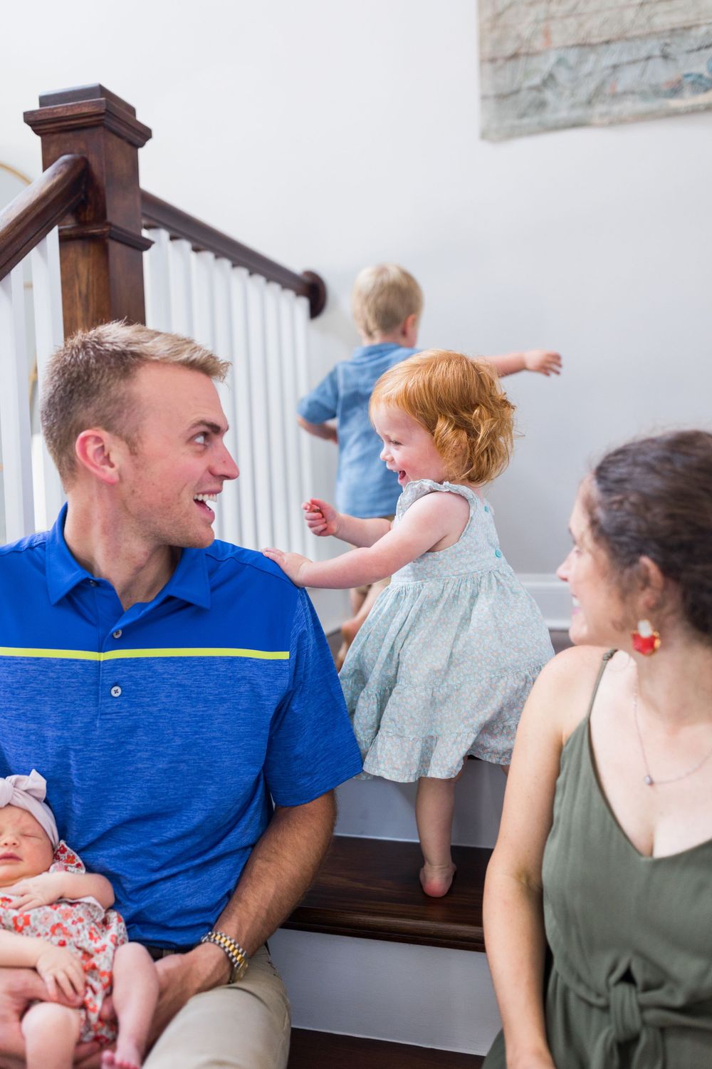 Family members share joyful moments while sitting together on indoor steps.