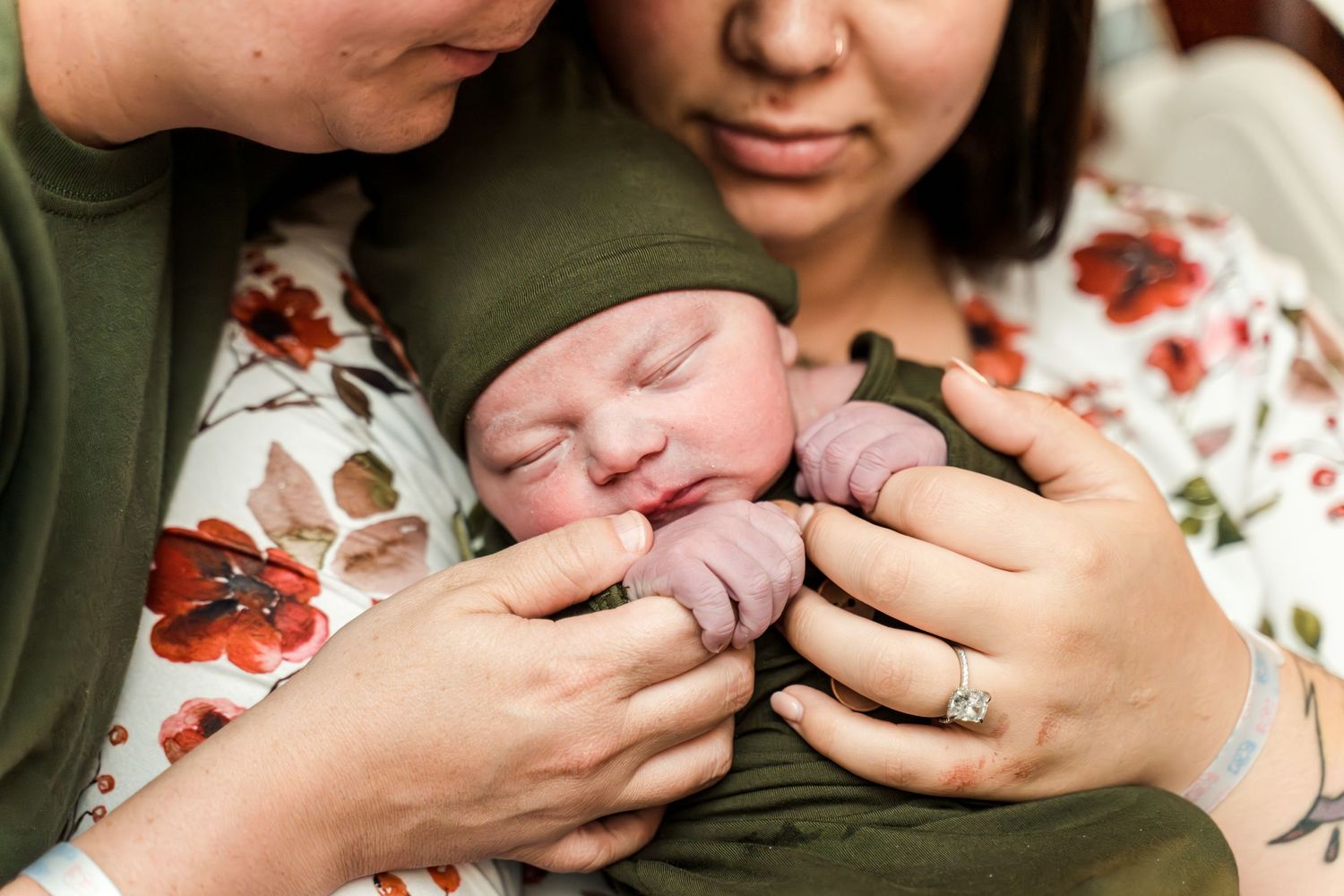 New parents tenderly holding their newborn baby.
