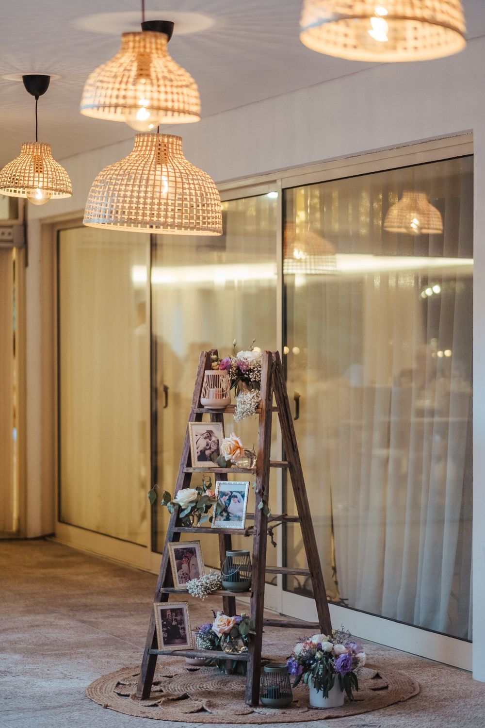 Uma escadaria vintage com candeeiros suspensos em vime e molduras cria um ambiente rústico perfeito para a decoração de um casamento.
