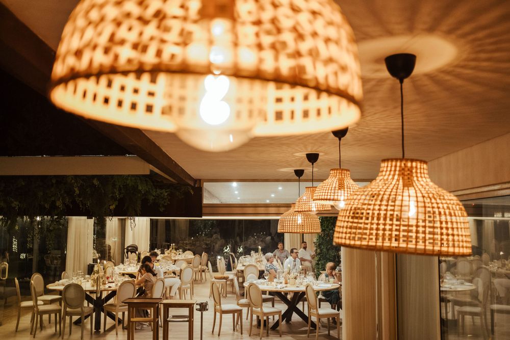 Candeeiros suspensos de tecido entrançado com luz quente e aconchegante criam um ambiente elegante num hall de receção.