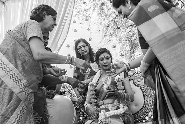 Candid black and white photo of a traditional Indian pre-wedding ceremony.