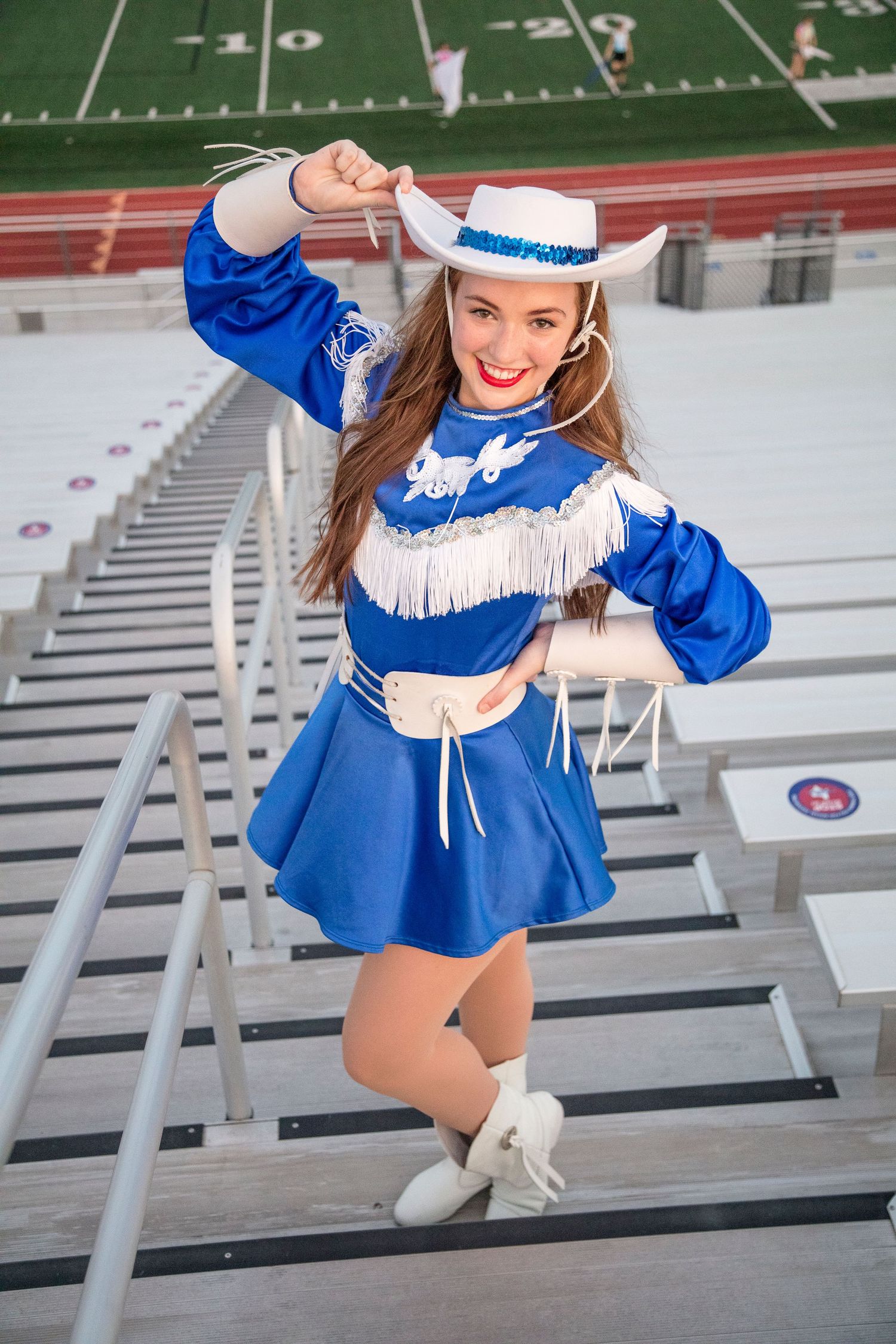 Dynamic shots of cheerleader performing routine on stadium bleachers in blue uniform.