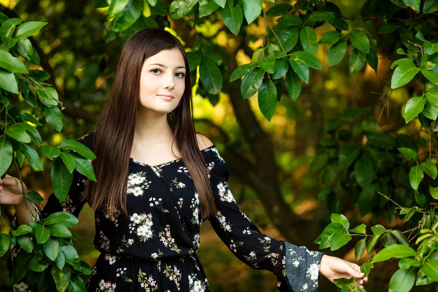 Portrait session in garden setting with yellow flowers and green foliage.