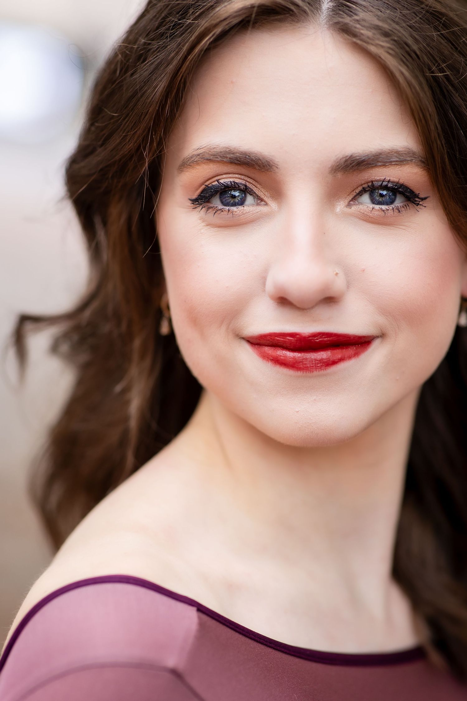 Glamorous portrait featuring burgundy dress and classic red lipstick.
