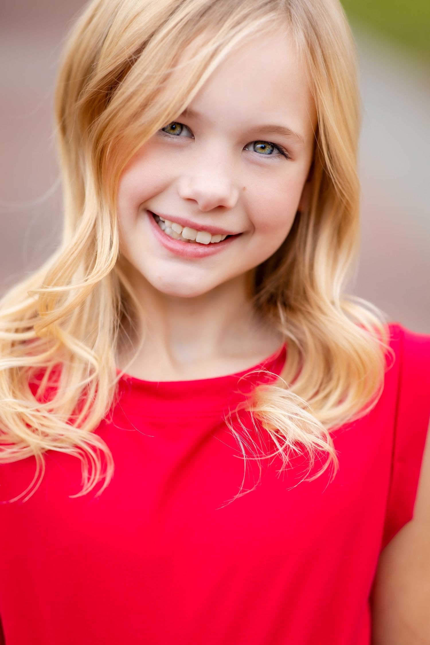 Bright portrait featuring red top and natural blonde hair styling.
