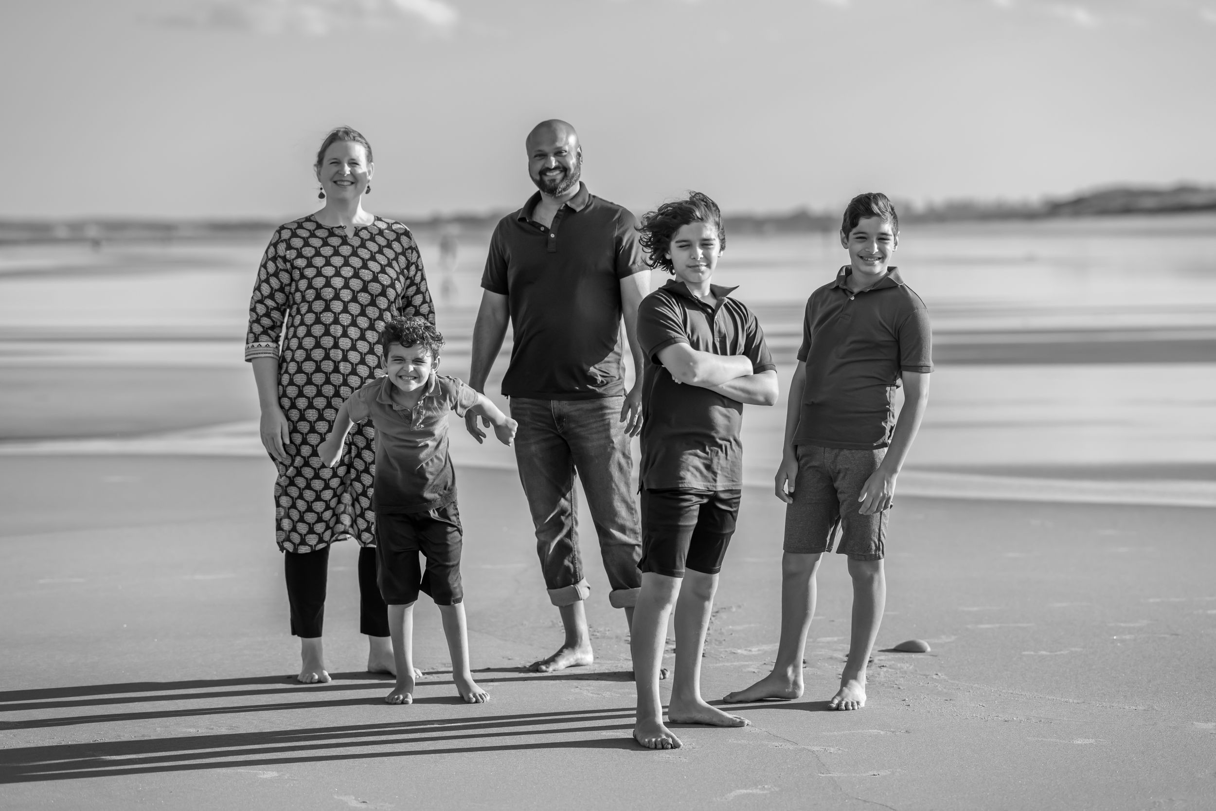 Black and white photograph of a multicultural family at the beach.