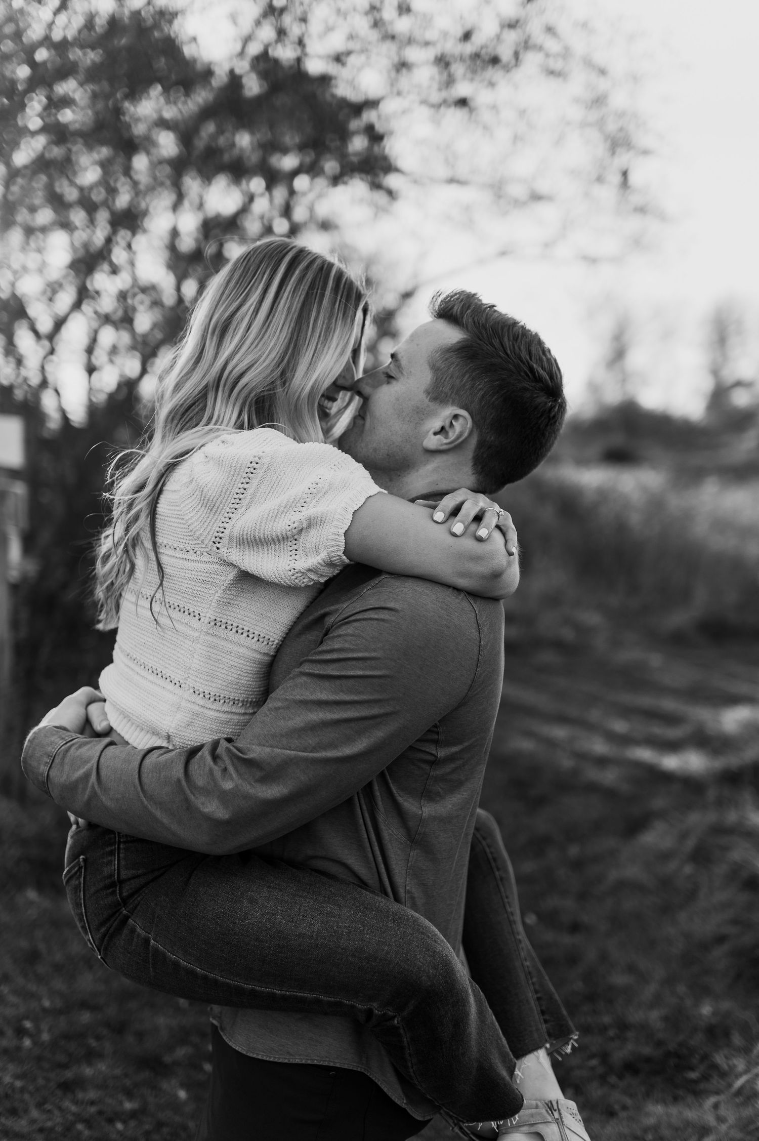Intimate black and white photos capture tender moments between a couple in a rustic outdoor setting.