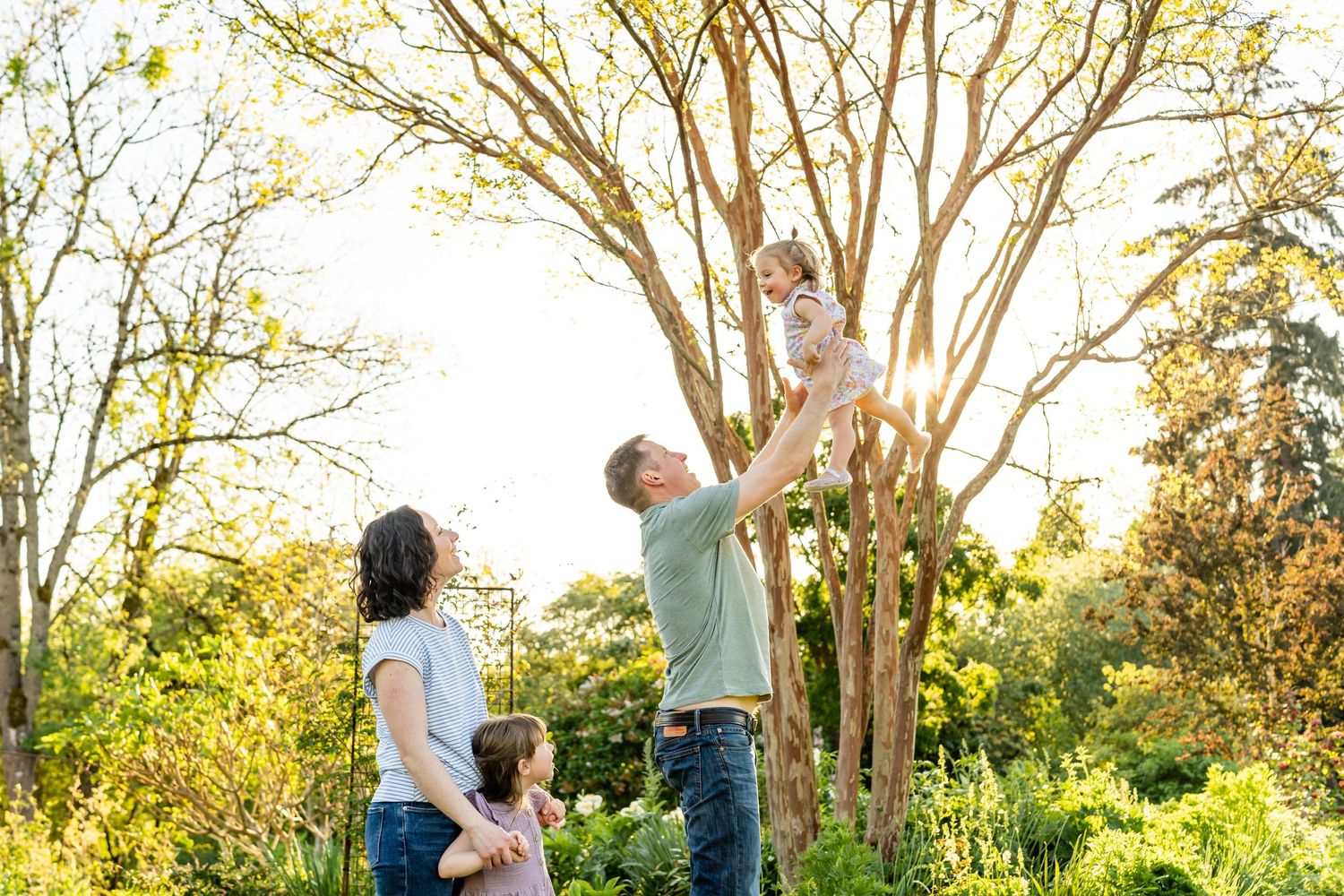 Father throws daughter into the air at the garden in Bellevue.