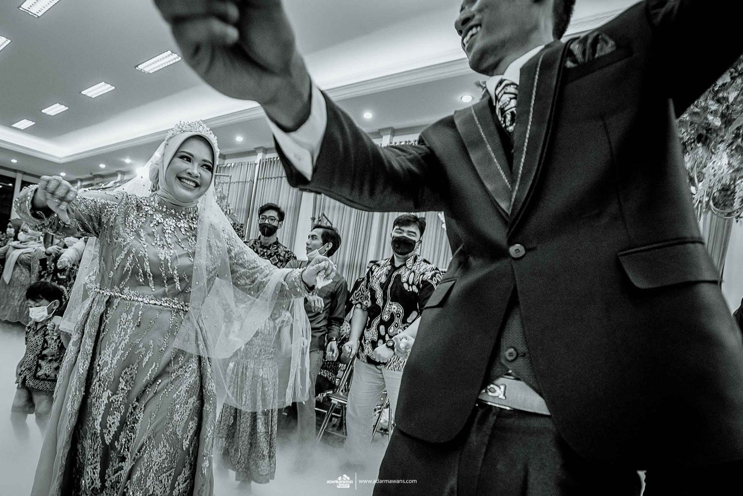 Black and white photo of wedding celebration with guests dancing and celebrating.