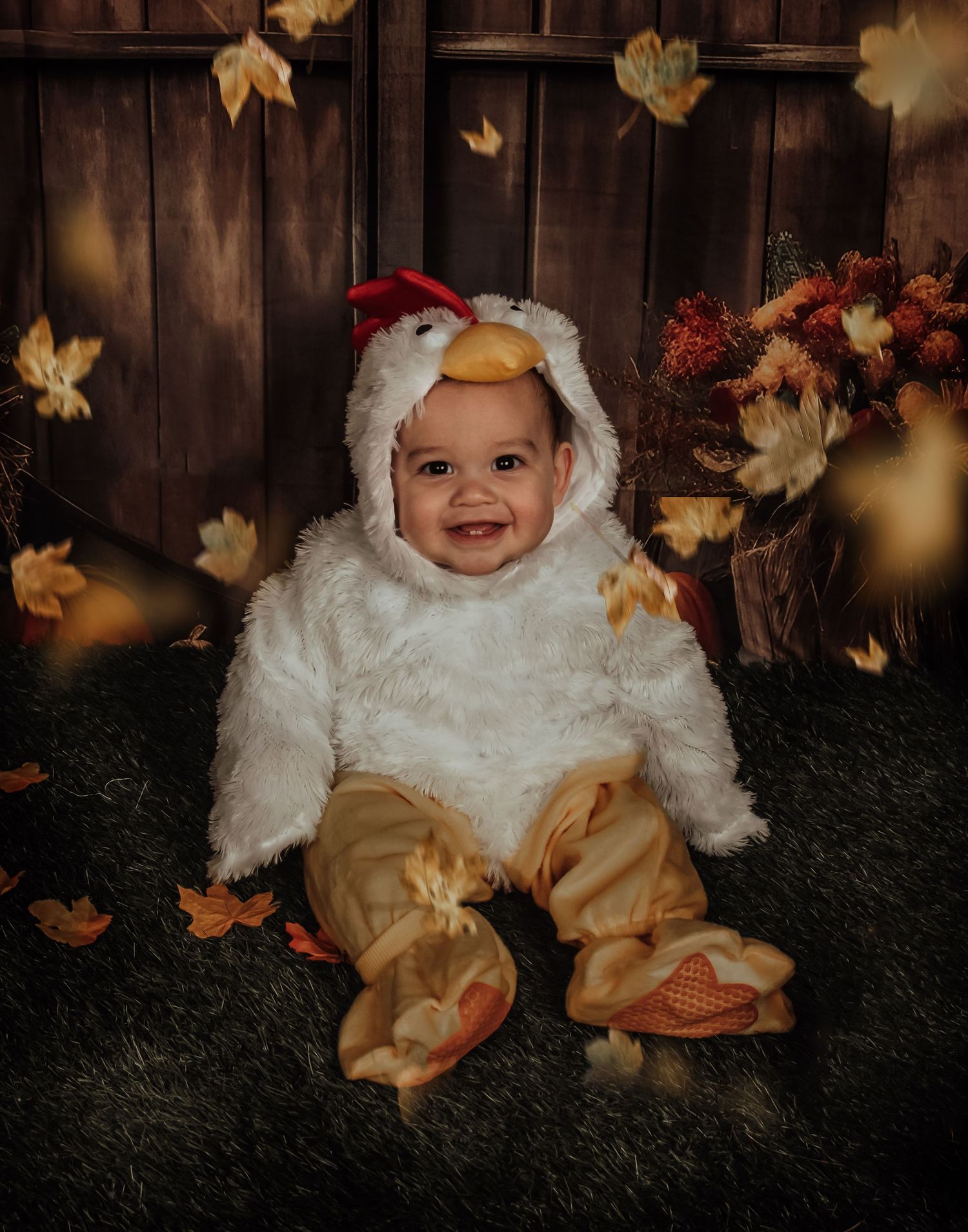 A charming costume photo featuring a white fuzzy outfit against an autumn-decorated wooden backdrop.