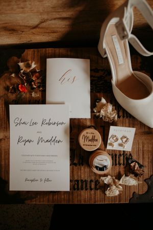 flat lay of bridal supplies on the morning of her wedding, vow books and jewellery