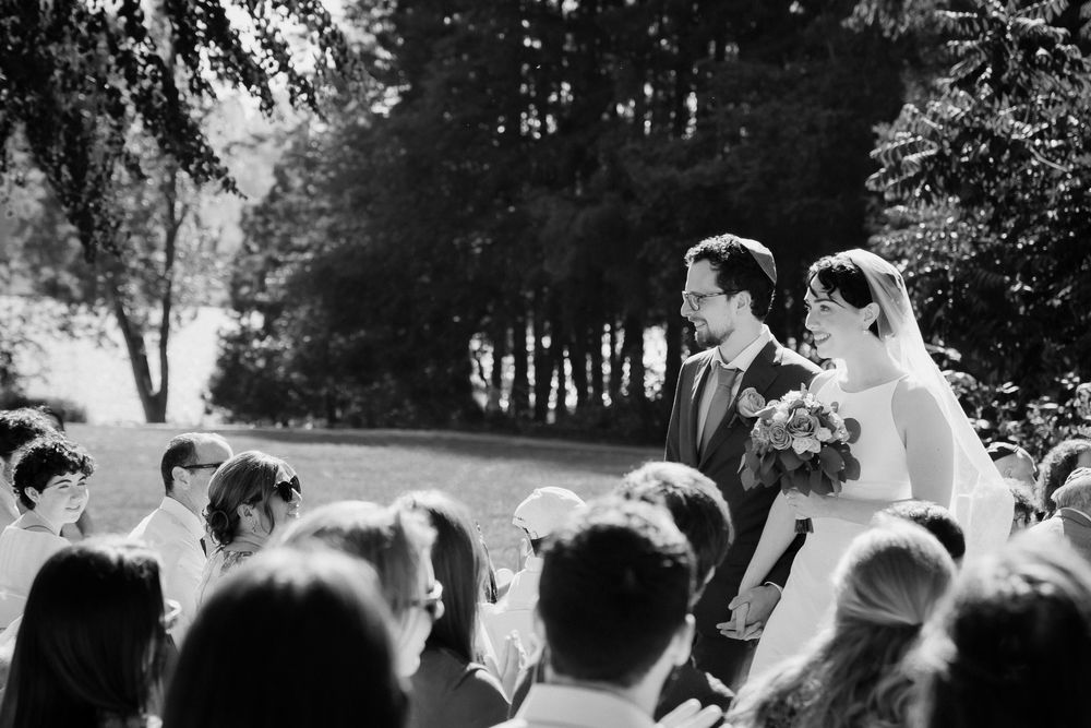 A newly wed couple walks down the aisle after their traditional jewish ceremony. They smile wide