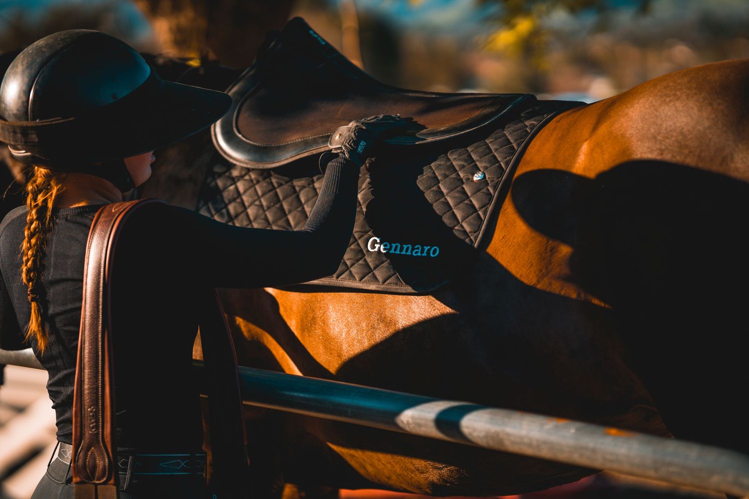 Close-up of brown leather horse saddle equipment with decorative stitching.