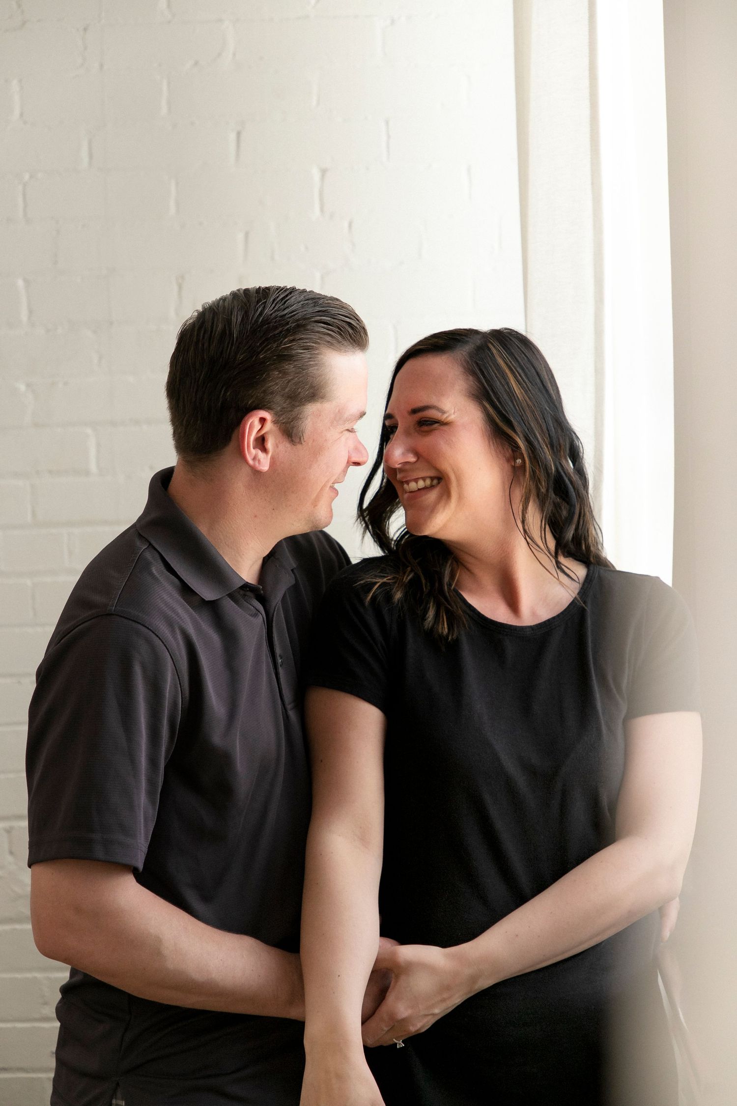 a couple in a studio smiling at one another in adoration
