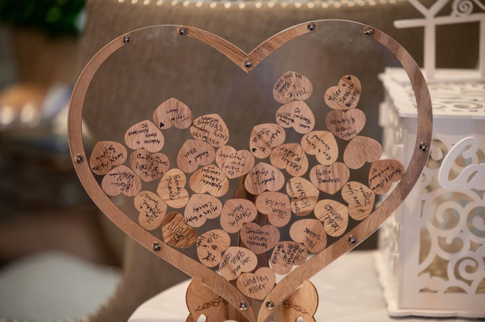Heart-shaped wedding guest book alternative with wooden hearts for signatures.