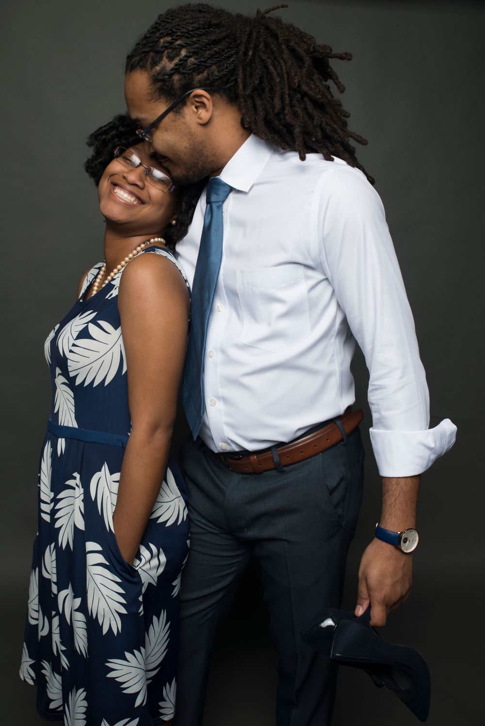 Intimate portrait of a couple in business attire sharing an affectionate moment.