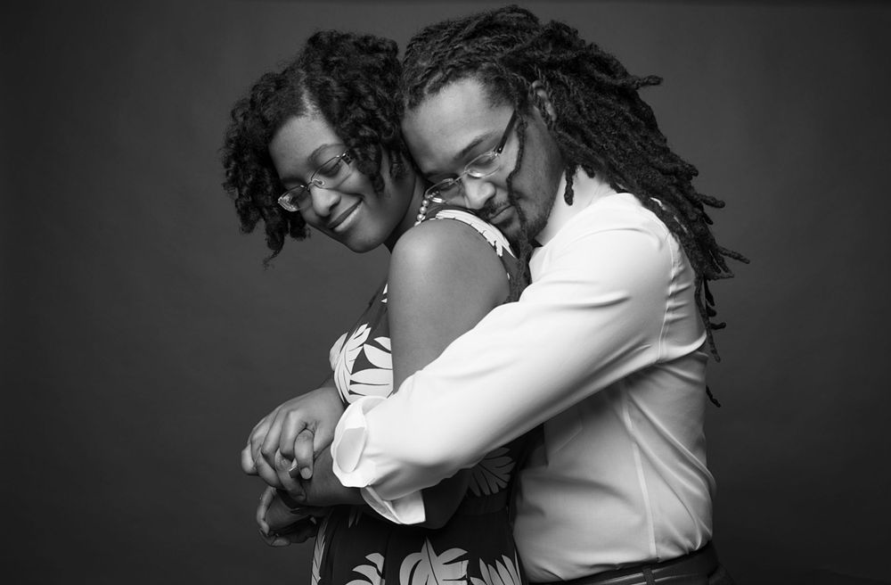 Black and white portrait of a couple embracing and laughing together.